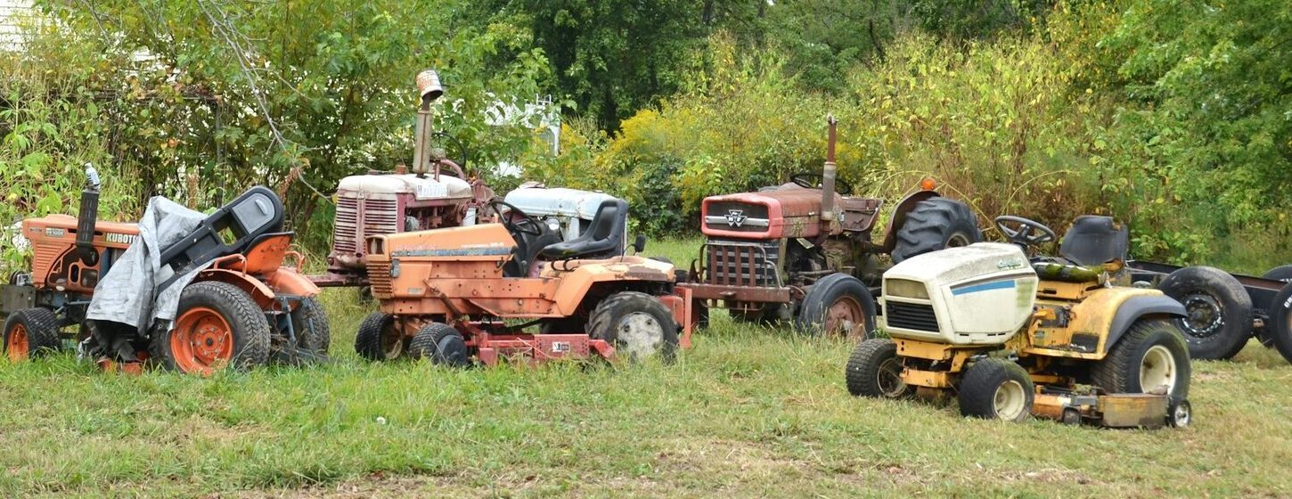 Lineup of mowers & garden tractors in a field