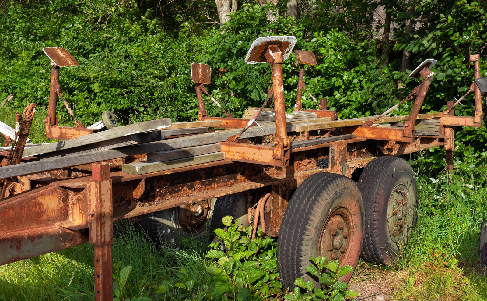 Small tandem-axle utility trailer standing on its own trailer tires