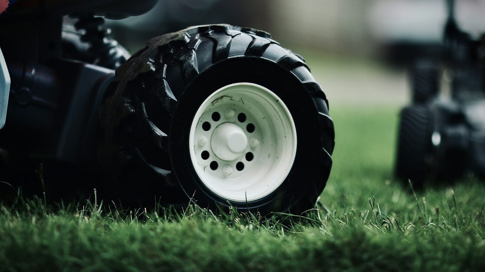 Close-up of a small ag-lug tire on a white steel wheel in turf