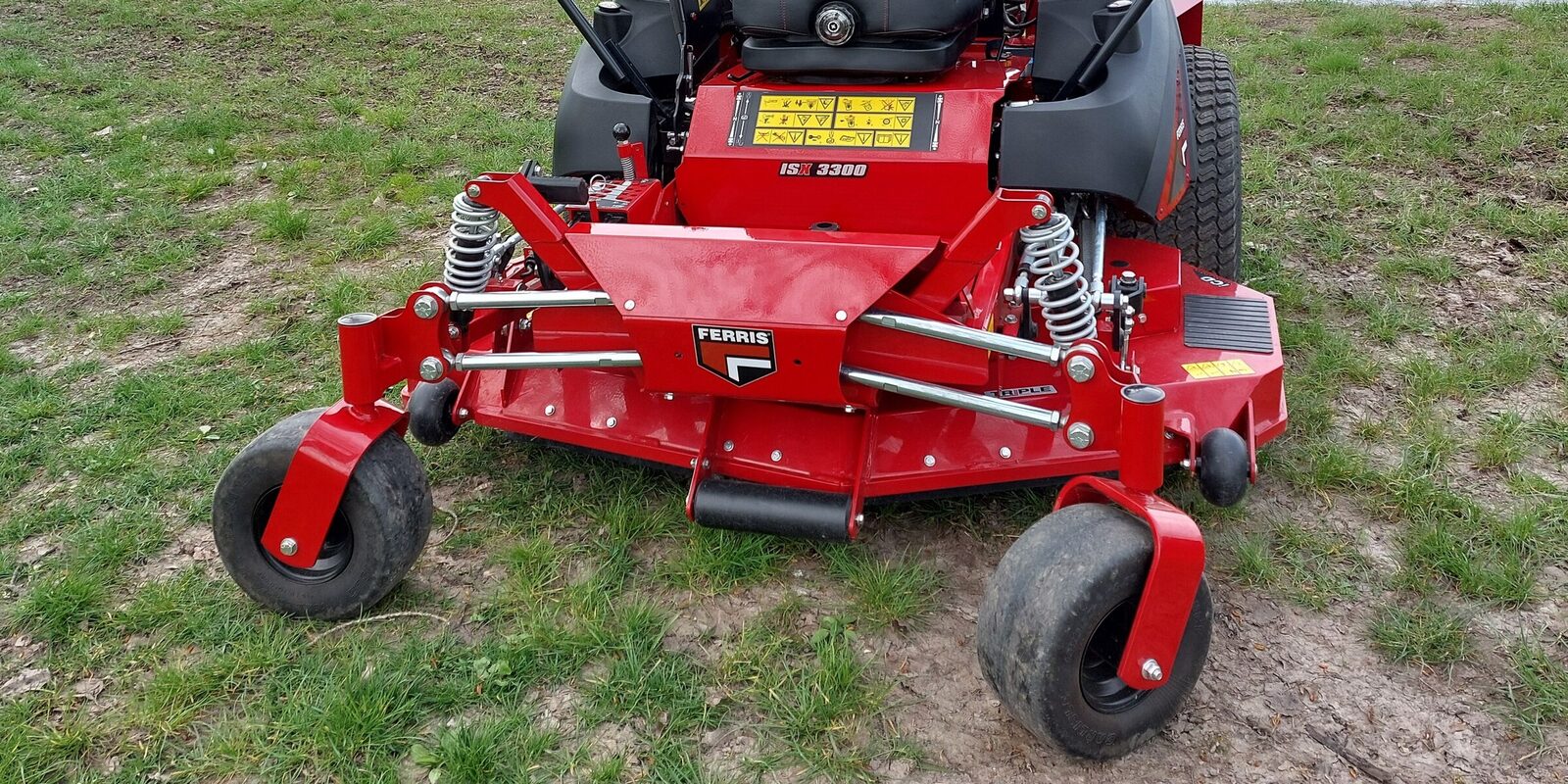 Zero-turn mower deck with both front caster tires and a rear drive tire in view